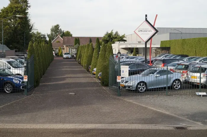 De ingang van het terrein aan de Antoniusstraat met het ruitbord en de laan